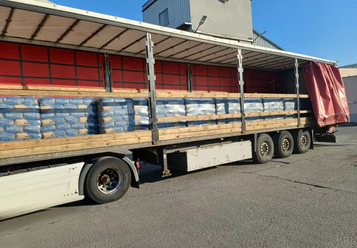 Na palecie ciężarówki ułożono worki z cementem. Widać ich sporo, gotowych do transportu.