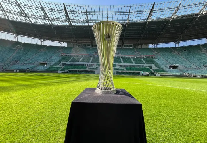 Błyszczący puchar Konfederacji UEFA na tle pustego stadionu.