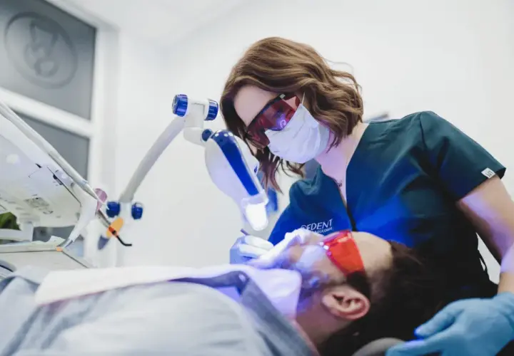 Dentystka wykonuje higienizację zębów w ciąży, dbając o zdrowy uśmiech przyszłej mamy.