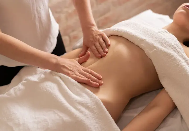 Mains douces prodiguant un massage ventre gonflé, apportant détente et soulagement.