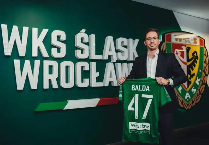 Dyrektor sportowy WKS Śląsk Wrocław, Balda, prezentuje zieloną koszulkę z numerem 47.