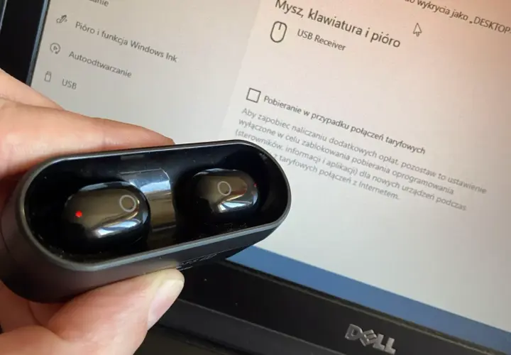 Słuchawki bezprzewodowe w etui, obok ekranu laptopa z ustawieniami USB. Jak podłączyć słuchawki przewodowe do komputera? To proste, wystarczy port.