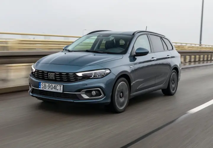 Niebieski Fiat Tipo kombi jedzie po moście. Prawidłowe ciśnienie w oponach zapewnia bezpieczeństwo.