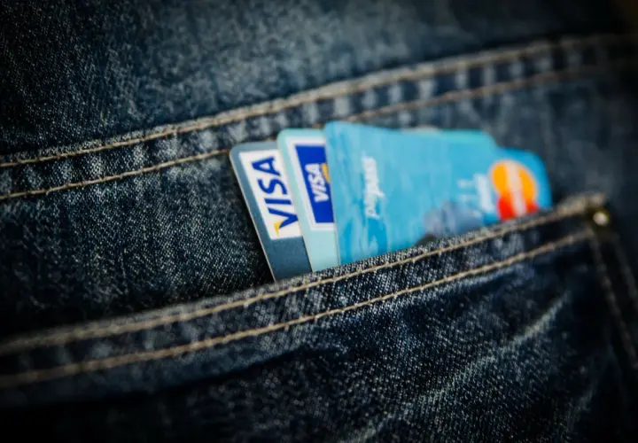 Dwie karty Visa i karta Paypass schowane w kieszeni jeansów. Wygodna karta prepaid na codzienne zakupy.