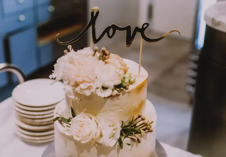 Elegancki tort weselny z napisem "love" i kwiatami. Wyobraź sobie jego pyszne tort weselny smaki!