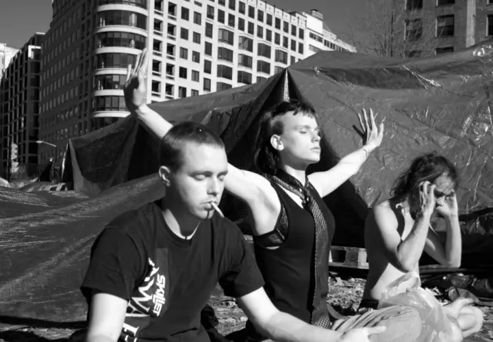 Trzech ludzi w pozie medytacyjnej. Jeden pali papierosa, drugi ma ręce w górze, trzeci zakrywa twarz. Medytacja skutki uboczne?