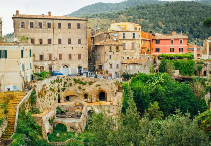 Vue d'ensemble de la Villa Gregoriana, avec ses bâtiments anciens, ses ruines et sa végétation luxuriante.