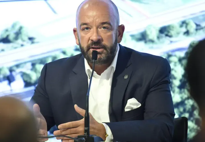 Jacek Sutryk z partnerem podczas konferencji prasowej. Mężczyzna w garniturze przemawia do mikrofonu.