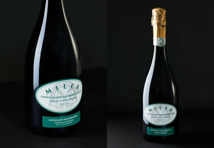 Dwie butelki prosecco. Jedna z nich ma złoty kapturek. Etykiety informują o pochodzeniu i zawartości procentowej alkoholu.