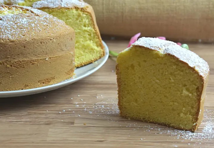 Un ciambellone soffice e alto, spolverato di zucchero a velo, pronto per essere gustato. La ricetta perfetta per una colazione golosa.
