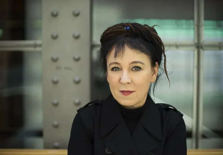 Olga Tokarczuk, laureatka Nagrody Nobla, w czarnym płaszczu. Jej życiorys to fascynująca podróż przez świat literatury.