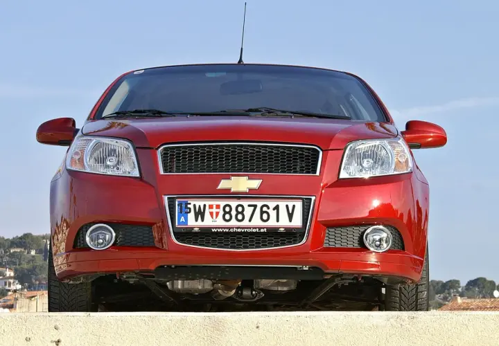 Czerwony samochód Chevrolet z austriacką tablicą rejestracyjną 15-W 88761 V.