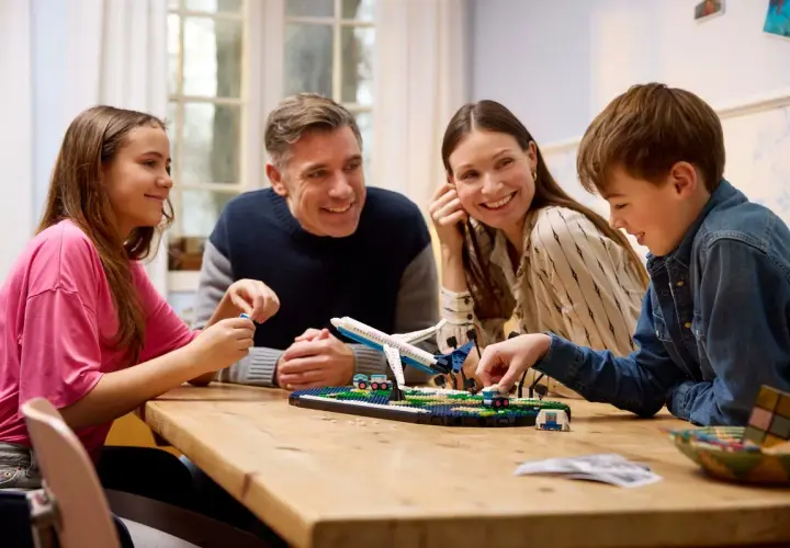 Familie baut gemeinsam ein Flugzeugmodell. Die Faszination LEGO verbindet Jung und Alt.