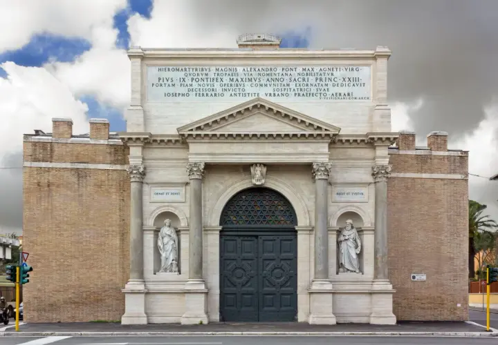 La Porta Pia, con le sue statue e iscrizioni, si erge maestosa sotto un cielo nuvoloso.