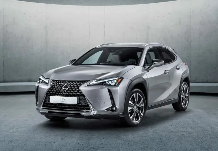 Srebrny Lexus UX 250h stoi na tle betonowej ściany. Elegancki crossover miejski gotowy na przygodę.