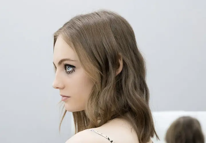 Chica con media melena escalada y maquillaje dramático en los ojos.