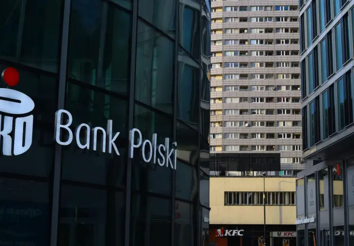 Logo PKO Bank Polski na szklanej fasadzie. W tle blok mieszkalny i KFC. PKO BP rekomendacje.