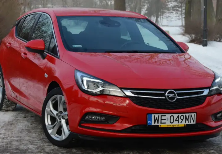 Czerwona Astra K 1.6 CDTI na tle zimowego krajobrazu.