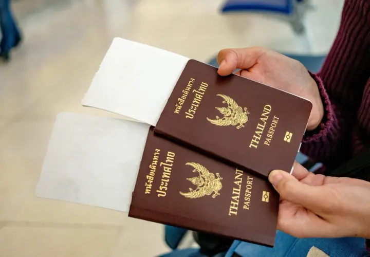 Zwei Reisepässe von Thailand werden gehalten, bereit für die Einreise. Ein 10-Jahres-Visum Thailand ist vielleicht schon beantragt.