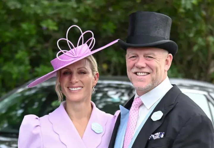 Ein Paar im eleganten Ascot Pferderennen Dresscode: Sie trägt einen lila Hut und Mantel, er einen Zylinder und Anzug.