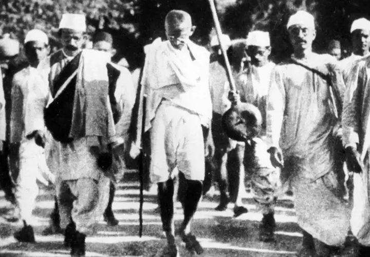 Mahatma Gandhi führt eine Gruppe von Menschen an, die sich auf einen Marsch vorbereiten.