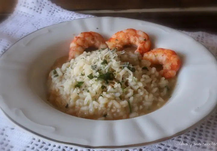 Delicioso risotto de langostinos cremoso, coronado con queso rallado y perejil fresco. Un plato principal que invita a disfrutar.