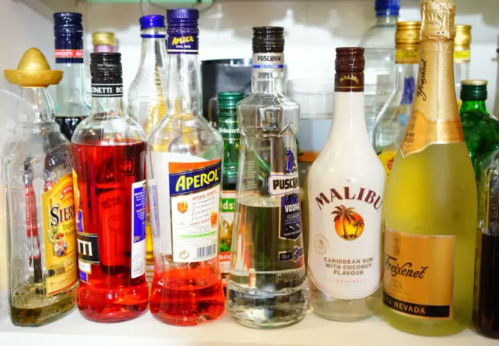 Na półce stoją butelki z alkoholami: Aperol, Malibu, Puschkin, Freixenet Cava i inne. Czy Schweppes ma alkohol? Nie ma go na zdjęciu.