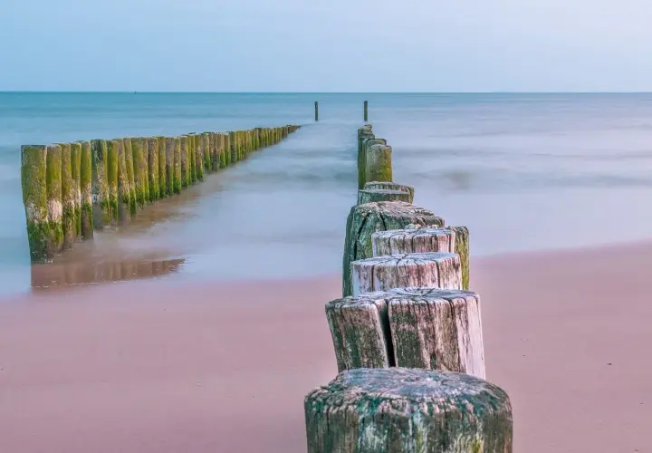 Drewniane pale na plaży, prowadzące do morza. Może tu jest najcieplejsza woda w Bałtyku?