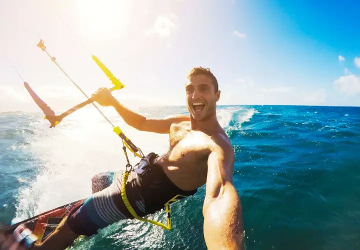 Szczęśliwy facet na kitesurfingu robi selfie. Wskazówka, jak zrobić dobre selfie facet: uśmiech i akcja!