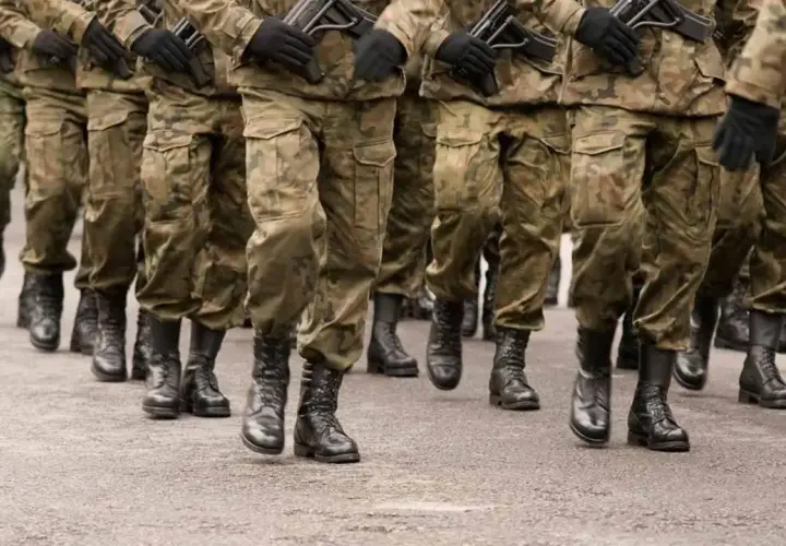 Żołnierze w mundurach polowych maszerują w zwartym szyku. Służby mundurowe w pełnym rynsztunku, gotowi do akcji.