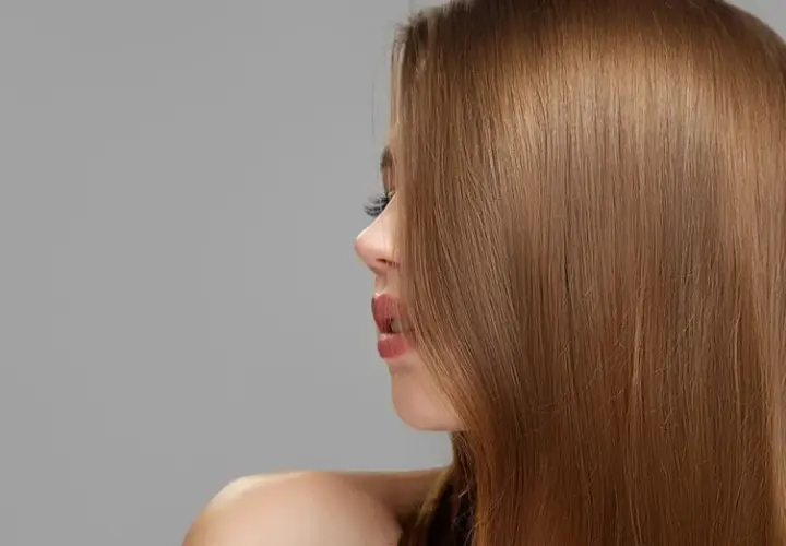 Perfil de mujer con cabello liso y sedoso de color de pelo castaño claro.