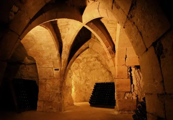 Cave voûtée de la maison Taittinger à Reims, où des milliers de bouteilles de champagne vieillissent patiemment.