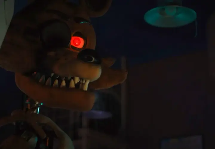 Occhio rosso minaccioso per la recensione di Five Nights at Freddy's. L'animatronic Foxy si avvicina nell'ombra.
