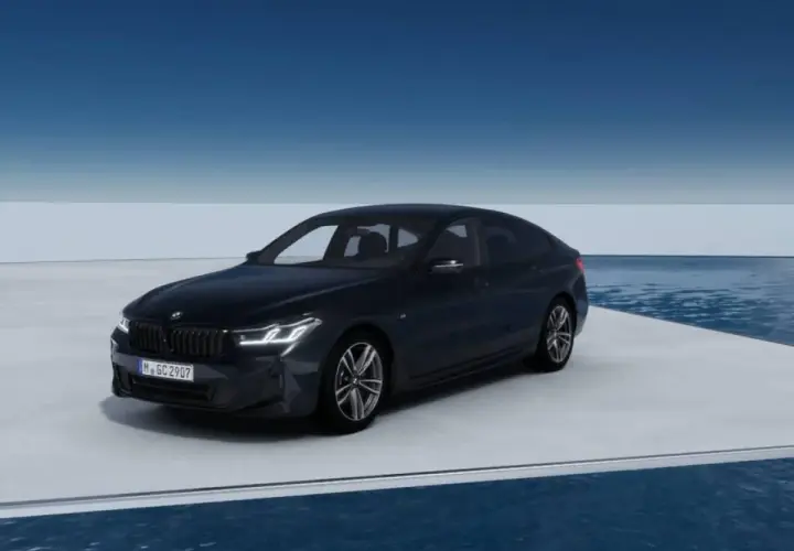 Eleganckie bmw g32 w ciemnym kolorze prezentuje się na platformie nad wodą, z błękitnym niebem w tle.