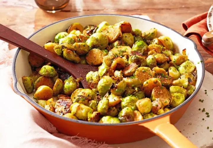 Leckere Rosenkohl Rezepte Pfanne mit gebratenem Rosenkohl und Kräutern, serviert in einer gusseisernen Pfanne.