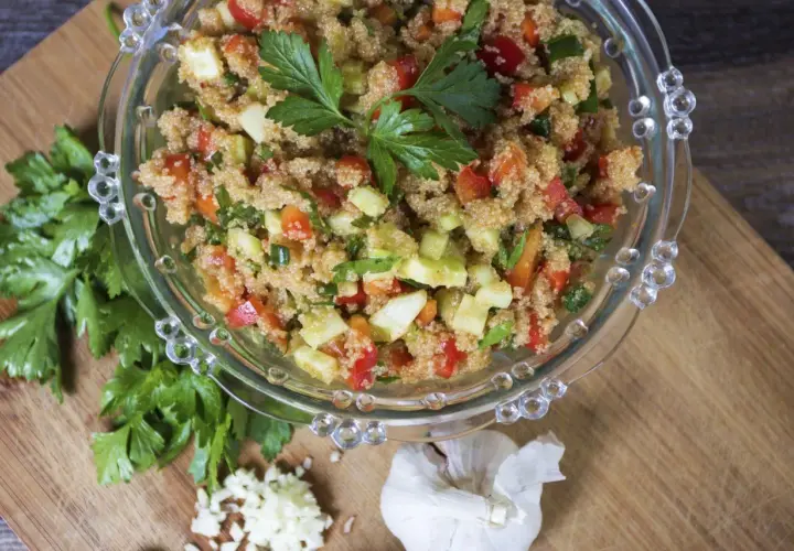 Insalata di amaranto colorata con pomodori, cetrioli e peperoni, guarnita con prezzemolo fresco.