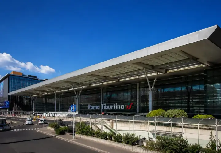 La moderna stazione di Roma Tiburtina, con la sua architettura in vetro e acciaio, accoglie viaggiatori diretti verso la metropolitana e oltre.