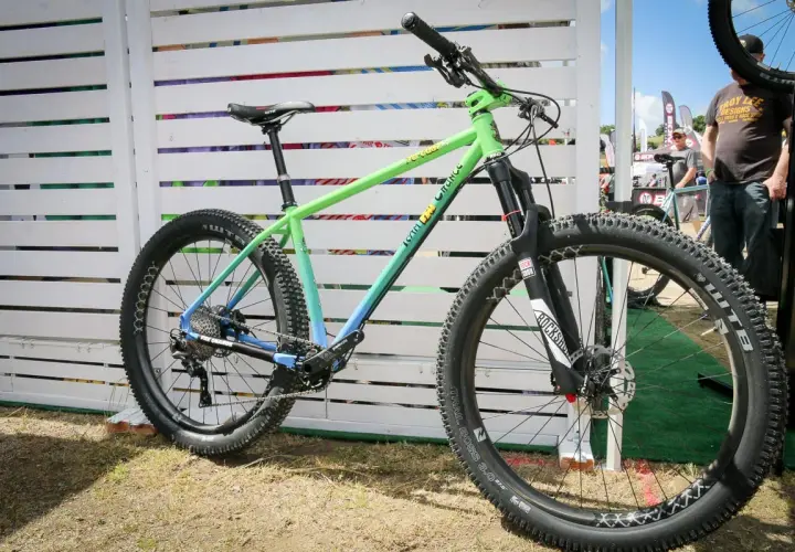 A green and blue gradient mountain bike, likely for a fat chance yo eddy review, with chunky tires and RockShox suspension.