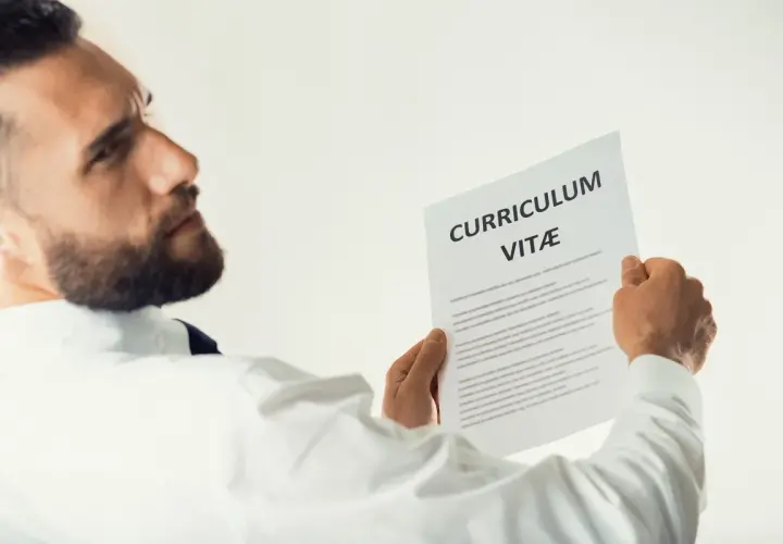 Mężczyzna z brodą analizuje CV, szukając kluczowych kompetencji przyszłości.
