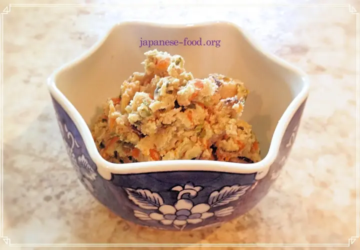 A bowl of okara salad, a healthy dish from okara recipes, filled with chopped vegetables like carrots and green beans.
