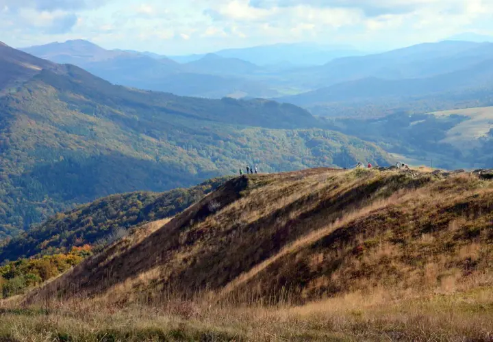 Widok na Bieszczady Połonina Wetlińska. Grupa turystów podziwia jesienne krajobrazy górskie.