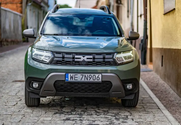 Zielony Dacia Duster na brukowanej uliczce. Sprawdź, jakie jest dacia duster spalanie i wybierz się na przygodę.