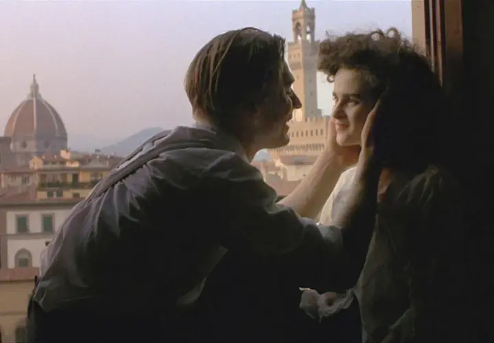 Ett par kysser varandra med Florens silhuett i bakgrunden, en ikonisk scen från en toscana film.