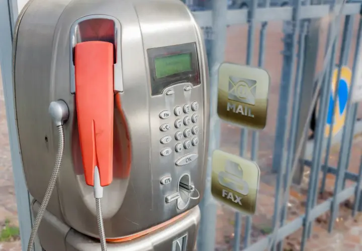 Stary unifon z pomarańczową słuchawką, obok ikony poczty i faksu.