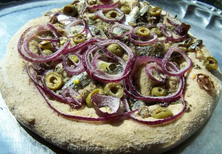 Pizza z anchois, oliwkami i czerwoną cebulą na chrupiącym cieście.