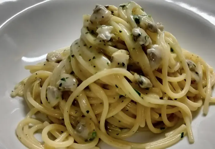Spaghetti alle vongole cremosi come al ristorante, un piatto invitante con pasta e molluschi in una salsa vellutata.