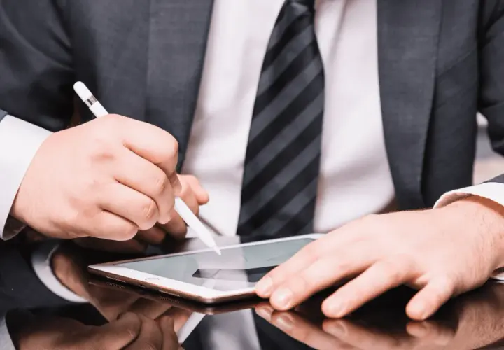 Hombre con traje firma un contrato con certificado digital en una tablet.