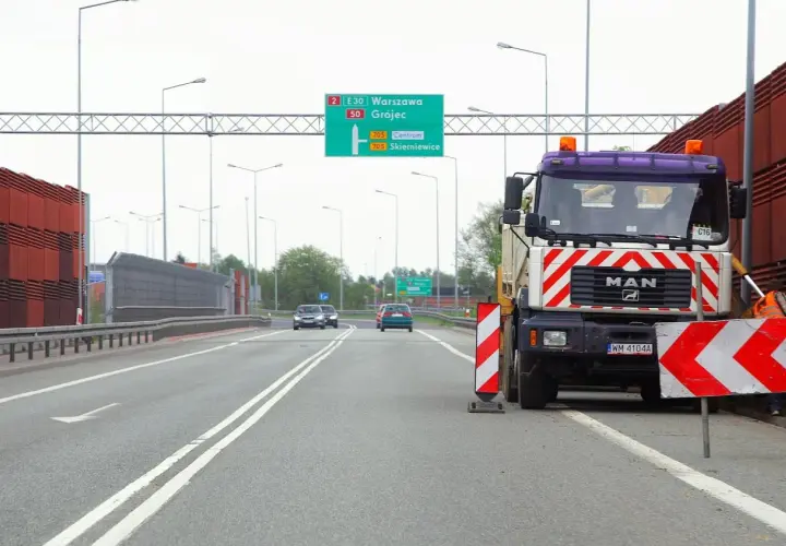 Ciężarówka MAN blokuje drogę, ostrzegając przed wyprzedzaniem na podwójnej ciągłej. Mandat za takie wykroczenie jest wysoki.