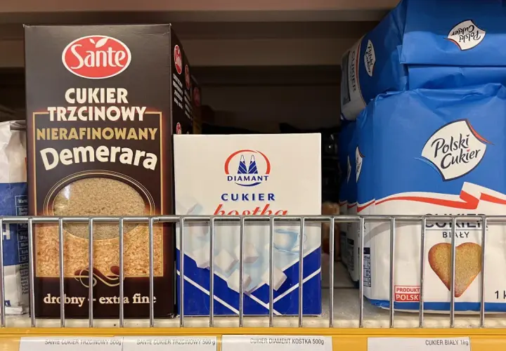 Półka sklepowa z różnymi rodzajami cukru: trzcinowym, białym w kostkach i w kryształkach.