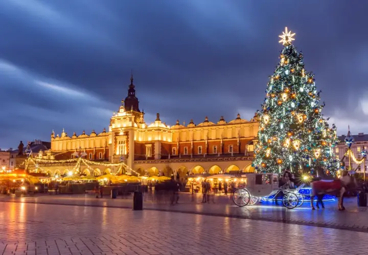 Magiczny jarmark bożonarodzeniowy krakow. Rozświetlona choinka, Sukiennice i karoca z końmi tworzą świąteczną atmosferę.